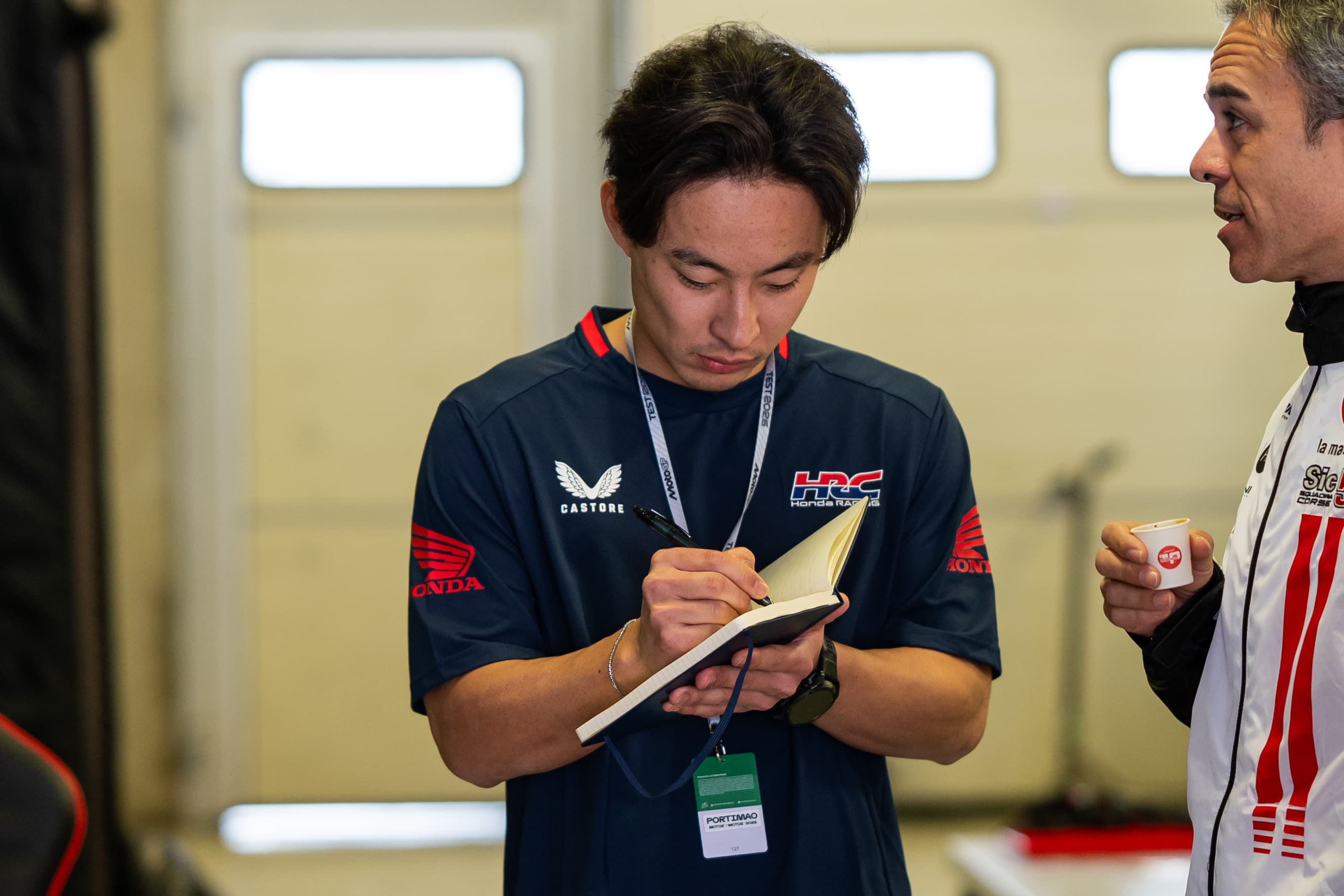 Tatsuki Suzuki writing post-session notes in the HRC garage at Portimão